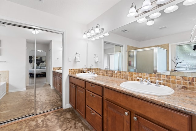 10711 Indian Trails Dr, Tomball, TX 77375 - bathroom featuring ensuite bath, double vanity, a shower stall, and backsplash