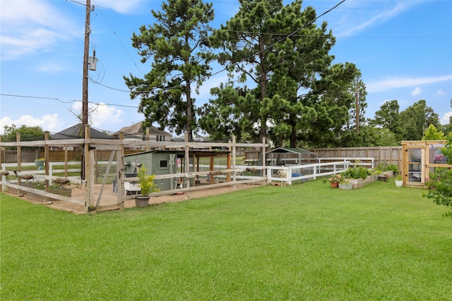 10711 Indian Trails Dr, Tomball, TX 77375 - view of yard featuring a vegetable garden, exterior structure, and an outbuilding