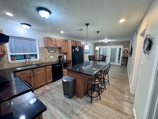 219 Lakeside Dr, Kemah, TX 77565 - kitchen with black appliances, a sink, french doors, a breakfast bar, and dark countertops