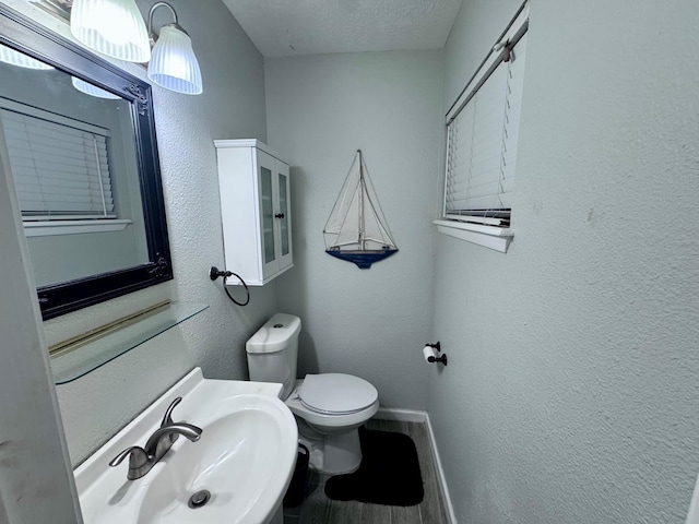 219 Lakeside Dr, Kemah, TX 77565 - bathroom with a sink, toilet, baseboards, a textured ceiling, and wood finished floors