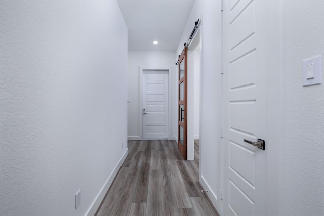 68 Fairway Dr, Trinity, TX 75862 - corridor featuring a barn door, baseboards, wood finished floors, and recessed lighting