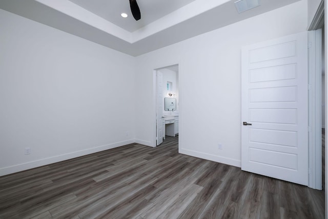 68 Fairway Dr, Trinity, TX 75862 - unfurnished bedroom with wood finished floors, baseboards, ensuite bath, a raised ceiling, and recessed lighting