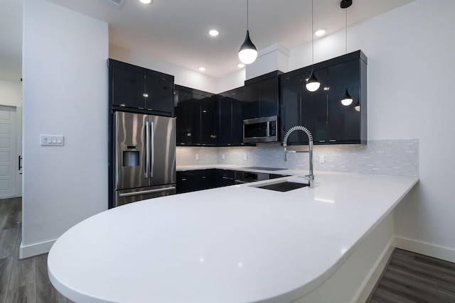 68 Fairway Dr, Trinity, TX 75862 - kitchen with appliances with stainless steel finishes, dark cabinetry, a peninsula, light countertops, and recessed lighting