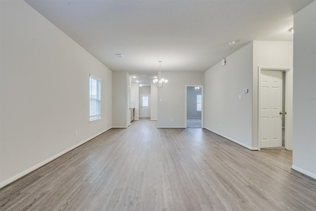 27398 Axis Deer Trl, Magnolia, TX 77354 - empty room featuring a chandelier, light wood finished floors, and healthy amount of natural light