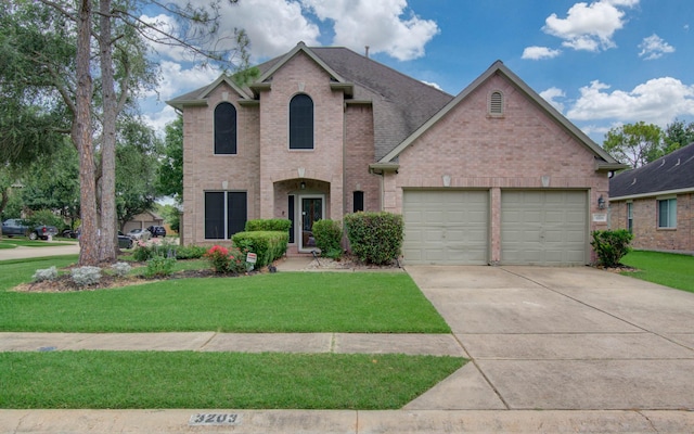 3203 Blaesser Dr, Pearland, TX 77584 - traditional-style house featuring an attached garage, brick siding, driveway, and a front lawn