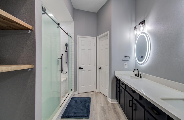 3203 Blaesser Dr, Pearland, TX 77584 - bathroom with a shower stall, wood finished floors, and double vanity
