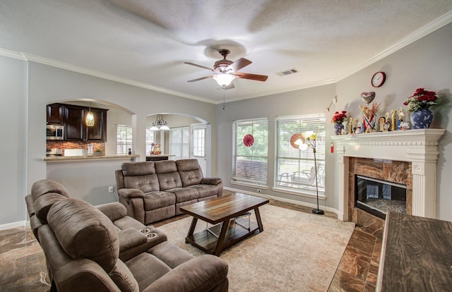 3203 Blaesser Dr, Pearland, TX 77584 - living room featuring arched walkways, ceiling fan, baseboards, crown molding, and a premium fireplace