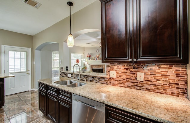 3203 Blaesser Dr, Pearland, TX 77584 - kitchen with dishwasher, a sink, arched walkways, backsplash, and a brick fireplace