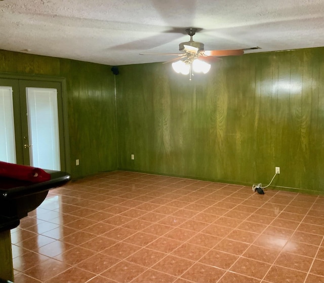 24360 Webb Rd, Porter, TX 77365 - tiled empty room with wooden walls, a textured ceiling, and a ceiling fan