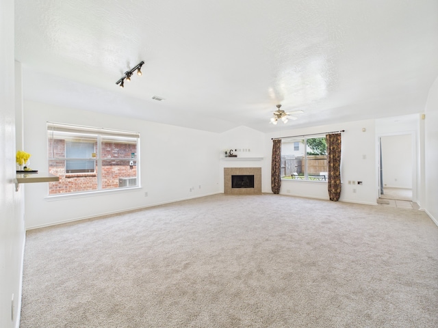 26940 Carriage Manor Ln, Kingwood, TX 77339 - unfurnished living room with ceiling fan, carpet, a tiled fireplace, and baseboards
