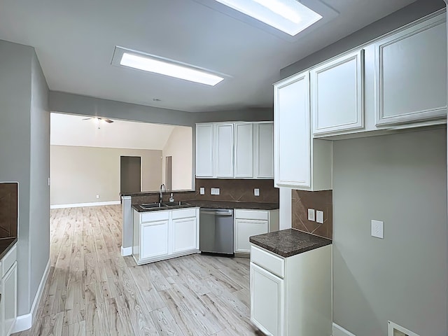 29375 Alba Rose Dr, Spring, TX 77386 - kitchen with stainless steel dishwasher, a sink, white cabinets, dark countertops, and backsplash