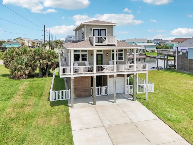 22212 Cantina Dr, Galveston, TX 77554 - view of front facade with a balcony, an attached garage, concrete driveway, roof with shingles, and a water view
