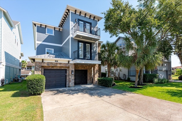 211 Valmar St, Kemah, TX 77565 - view of front facade featuring a balcony, concrete driveway, a front yard, stone siding, and an attached garage