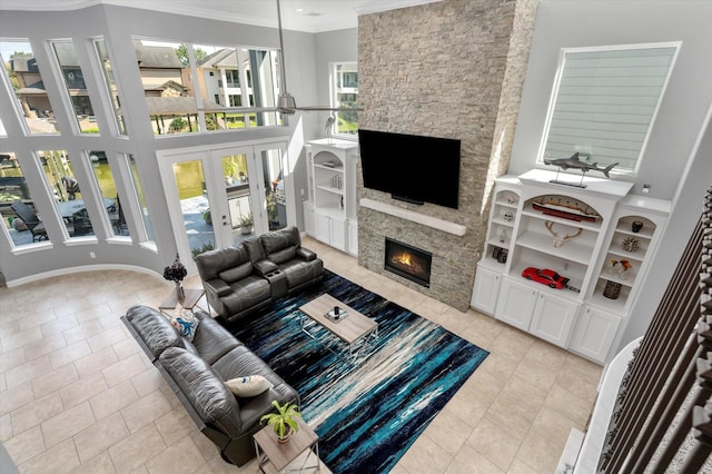 211 Valmar St, Kemah, TX 77565 - living room featuring a fireplace, crown molding, light tile patterned floors, french doors, and built in shelves