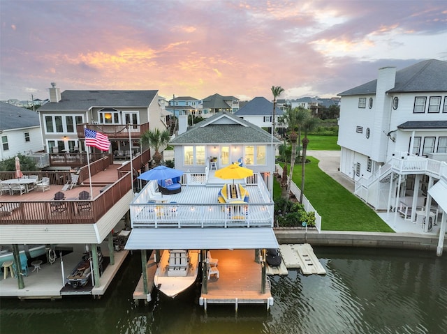 3906 Bridge Harbor Dr, Galveston, TX 77554 - dock area with boat lift, a residential view, and a deck with water view
