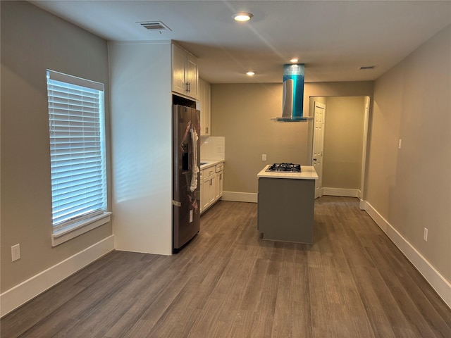 8302 Tavenor Ln, Houston, TX 77075 - kitchen featuring wall chimney exhaust hood, stainless steel appliances, light countertops, dark wood-style flooring, and baseboards