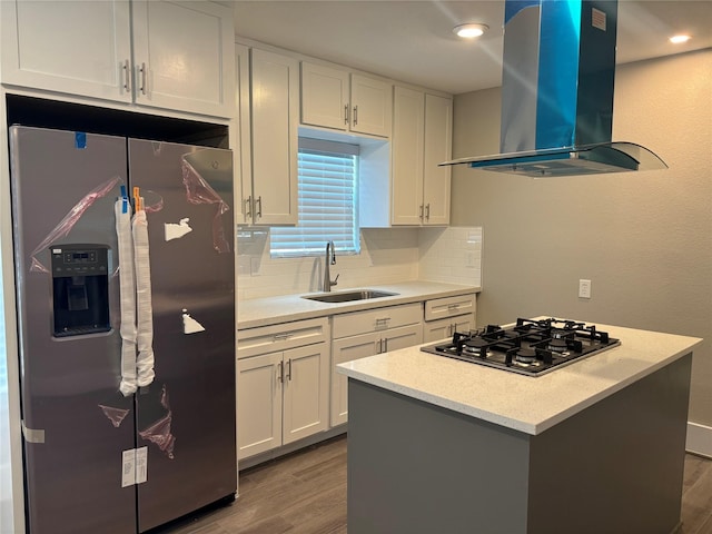 8302 Tavenor Ln, Houston, TX 77075 - kitchen featuring stainless steel appliances, wall chimney exhaust hood, a sink, wood finished floors, and tasteful backsplash