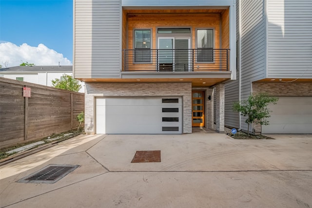 1305 E 27th St Unit A, Houston, TX 77009 - contemporary home featuring a balcony, an attached garage, driveway, and stone siding