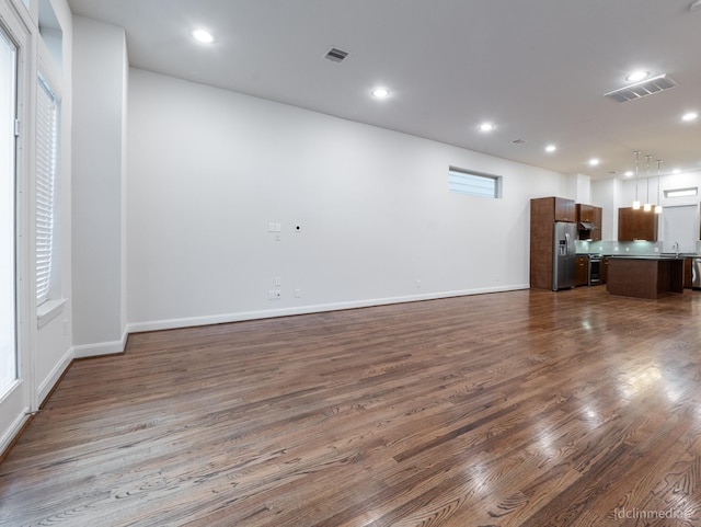 1224 Thompson, Houston, TX 77007 - unfurnished living room with dark wood-style floors, baseboards, recessed lighting, and a sink