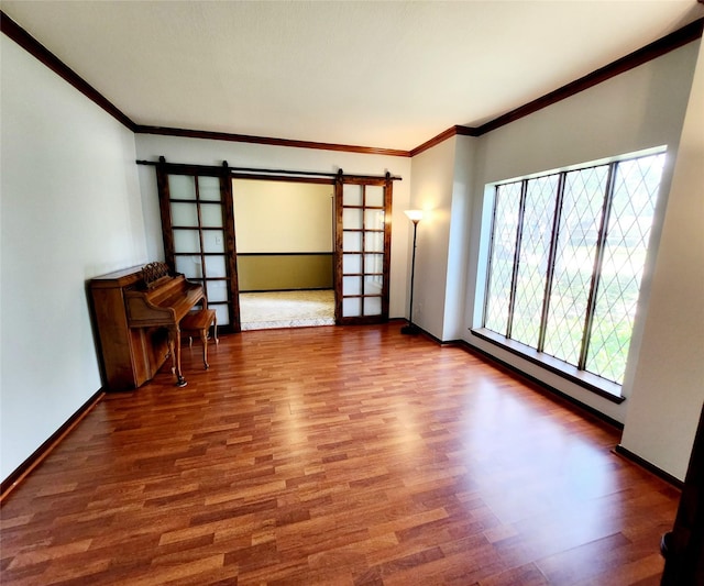15903 Ridge Park Dr, Houston, TX 77095 - empty room featuring a barn door, wood finished floors, crown molding, and baseboards