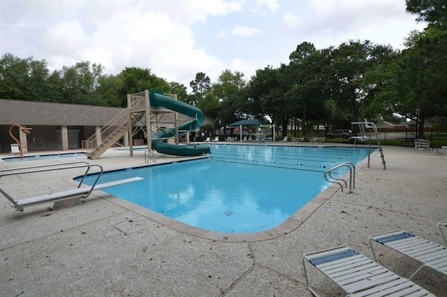 15903 Ridge Park Dr, Houston, TX 77095 - community pool with a patio area, a water slide, view of wooded area, and a diving board