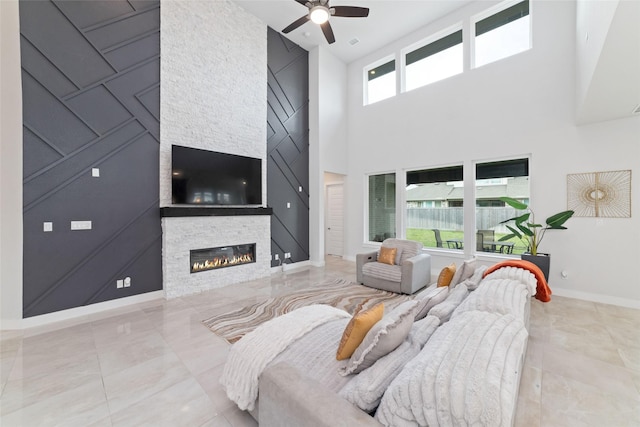 11023 White Caterpillar Dr, Cypress, TX 77433 - tiled living area featuring a fireplace, a ceiling fan, a towering ceiling, and baseboards