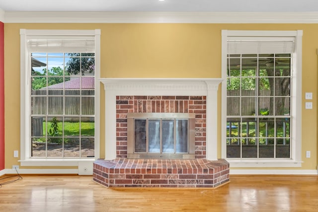 1022 Pinewood Ln, Seabrook, TX 77586 - unfurnished living room with wood finished floors, a brick fireplace, ornamental molding, and baseboards