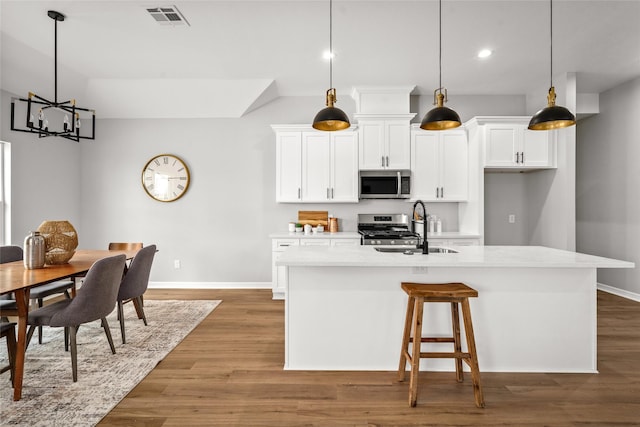 14307 Laredo St, Houston, TX 77015 - kitchen featuring appliances with stainless steel finishes, light wood finished floors, white cabinetry, and recessed lighting
