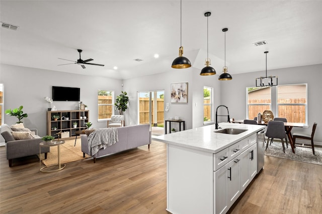 14307 Laredo St, Houston, TX 77015 - kitchen with open floor plan, light wood-style floors, ceiling fan, white cabinets, and hanging light fixtures