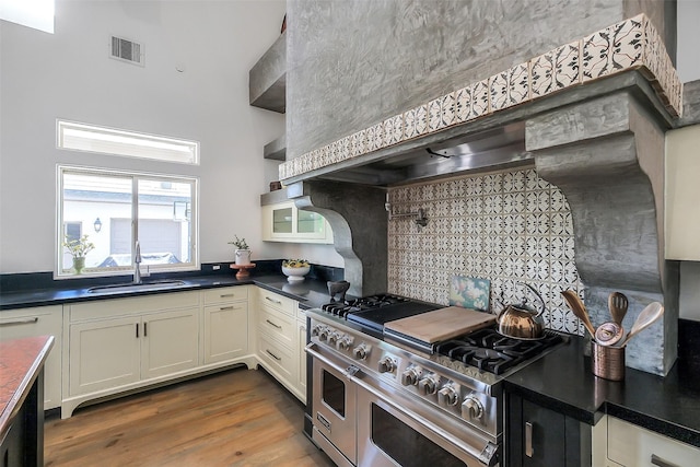4002 Old Chocolate Bayou Rd Unit Cr89, Manvel, TX 77578 - kitchen featuring double oven range, a sink, dark countertops, decorative backsplash, and wood finished floors