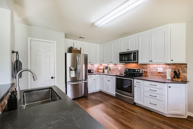 4719 Redbud Place Ln, Richmond, TX 77469 - kitchen with appliances with stainless steel finishes, a sink, dark countertops, and dark wood-type flooring