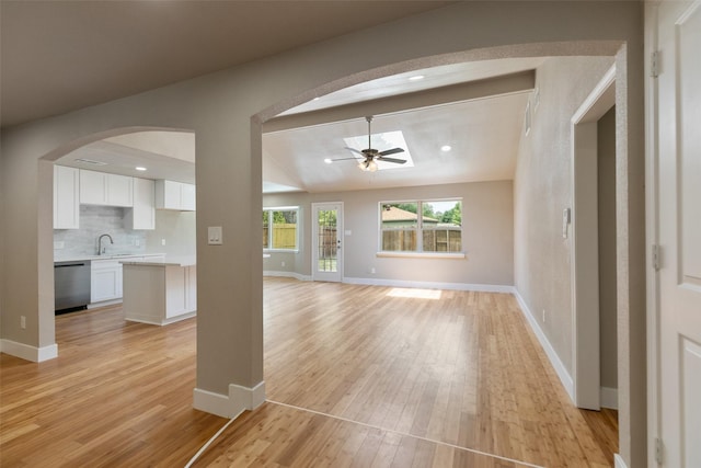 12406 Whittington Dr, Houston, TX 77077 - unfurnished living room with ceiling fan, vaulted ceiling, light wood finished floors, arched walkways, and baseboards