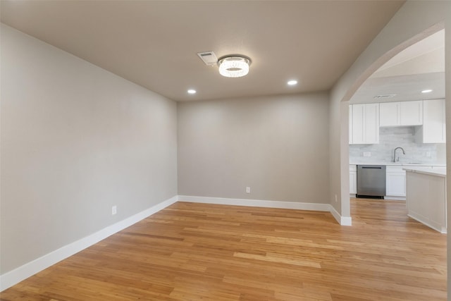 12406 Whittington Dr, Houston, TX 77077 - empty room with baseboards, recessed lighting, light wood-style floors, a sink, and arched walkways