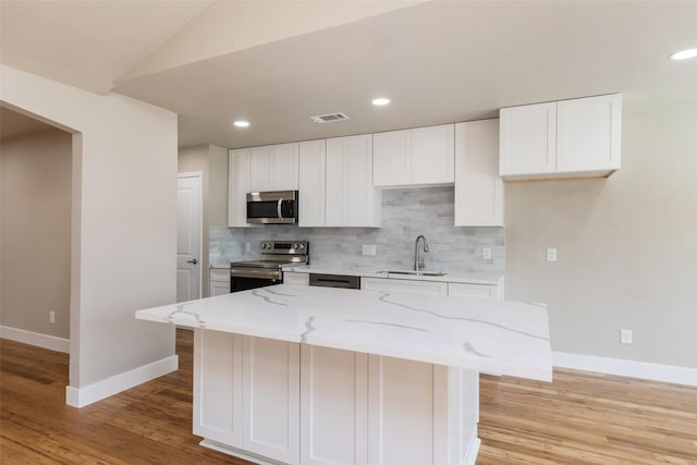 12406 Whittington Dr, Houston, TX 77077 - kitchen with stainless steel appliances, a sink, baseboards, tasteful backsplash, and light stone countertops