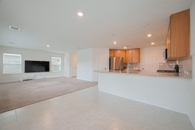 12327 Buck Sable Ln, Houston, TX 77044 - kitchen featuring stainless steel appliances, light colored carpet, recessed lighting, light stone countertops, and a peninsula