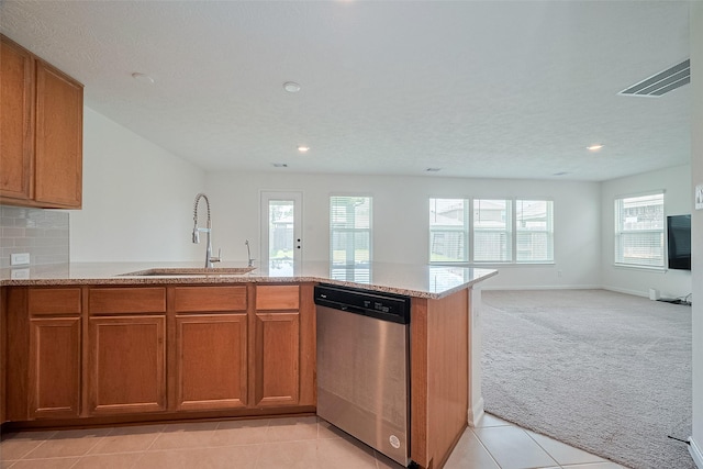 12327 Buck Sable Ln, Houston, TX 77044 - kitchen featuring stainless steel dishwasher, brown cabinetry, light colored carpet, open floor plan, and light stone counters