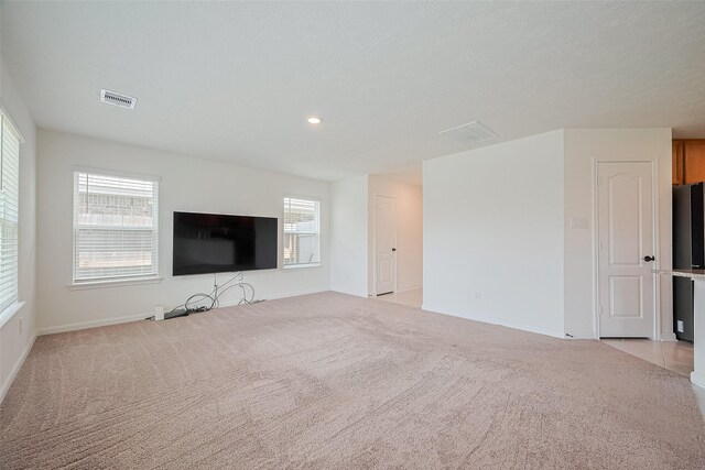 12327 Buck Sable Ln, Houston, TX 77044 - unfurnished living room with light colored carpet, healthy amount of natural light, and recessed lighting