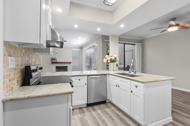 161 Litchfield Ln, Houston, TX 77024 - kitchen with dishwasher, a fireplace, exhaust hood, crown molding, and a peninsula