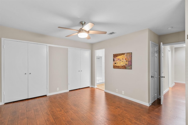 161 Litchfield Ln, Houston, TX 77024 - unfurnished bedroom featuring hardwood / wood-style floors, two closets, connected bathroom, and a ceiling fan