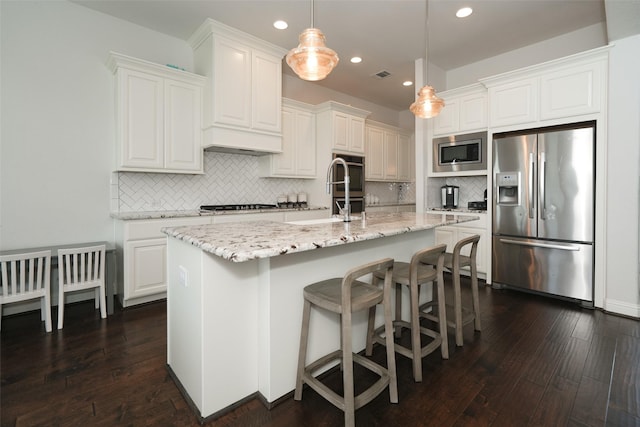 21015 Arden Park Dr, Richmond, TX 77407 - kitchen with appliances with stainless steel finishes, recessed lighting, dark wood-style flooring, backsplash, and an island with sink