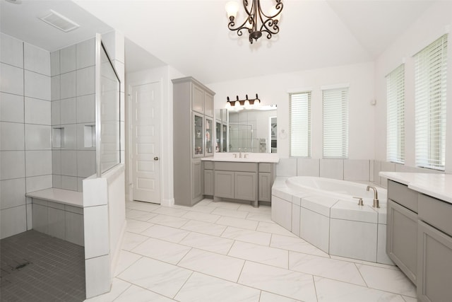 21015 Arden Park Dr, Richmond, TX 77407 - full bathroom with two vanities, lofted ceiling, a bath, a tile shower, and a chandelier