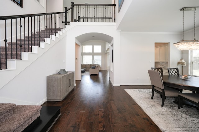 21015 Arden Park Dr, Richmond, TX 77407 - dining room with dark wood-type flooring, arched walkways, baseboards, ornamental molding, and stairs