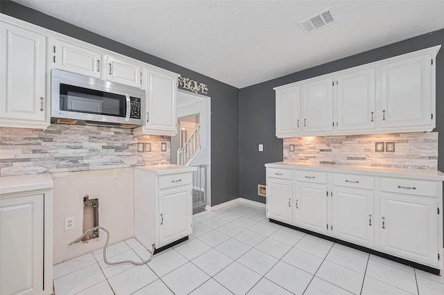 3718 Sweetgum Hill Ln, Houston, TX 77345 - kitchen featuring stainless steel microwave, light countertops, and white cabinets