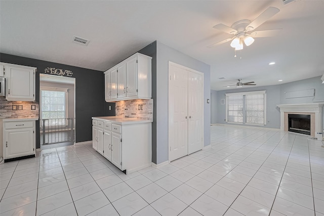 3718 Sweetgum Hill Ln, Houston, TX 77345 - kitchen featuring a ceiling fan, light countertops, backsplash, and white cabinets