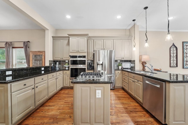 121 E 22nd St, Houston, TX 77008 - kitchen with a peninsula, appliances with stainless steel finishes, a sink, a center island, and backsplash