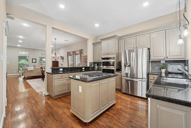 121 E 22nd St, Houston, TX 77008 - kitchen with appliances with stainless steel finishes, a sink, a peninsula, wood finished floors, and a center island