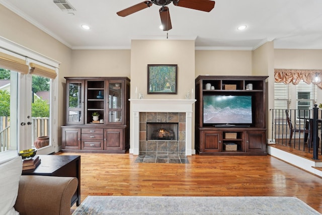 121 E 22nd St, Houston, TX 77008 - living room with wood finished floors, a ceiling fan, a fireplace, ornamental molding, and recessed lighting