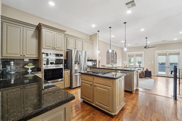 121 E 22nd St, Houston, TX 77008 - kitchen featuring appliances with stainless steel finishes, french doors, a center island, backsplash, and a peninsula