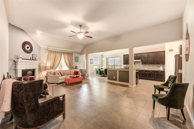 6119 Cresting Knolls Cir, Richmond, TX 77407 - living room with light tile patterned floors, vaulted ceiling, a ceiling fan, and a glass covered fireplace