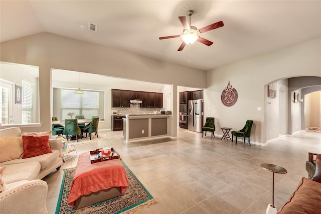 6119 Cresting Knolls Cir, Richmond, TX 77407 - living room featuring arched walkways, a ceiling fan, vaulted ceiling, and light tile patterned floors